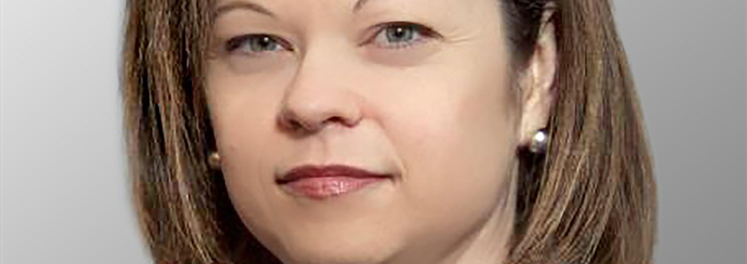 Head shot of a female with brown chin length hair wearing a purple shirt and black suit coat